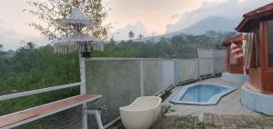 a bath tub sitting on a patio next to a fence at Channel Stay at Machaka Villa Bandungan in Bandungan