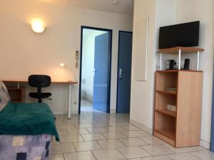 a room with a bed and a desk and a television at Appartement 2 pièces La Rochelle - LR030-B11 in La Rochelle