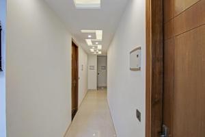 ニューデリーにあるHotel O THE CRIMSON PALACEの白壁の廊下、ドアのある長い廊下