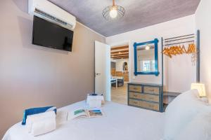 a bedroom with a bed with a tv on the wall at Villa Buganvilla en Salobreña in Salobreña +29 photos
