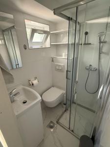 ein Badezimmer mit Dusche, Toilette und Waschbecken in der Unterkunft Mili Minihouse in Kaštela