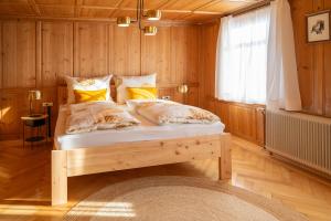 a bedroom with a bed with wooden walls and a window at Ferienwohnung Ritter in Schwarzenberg im Bregenzerwald +13 photos
