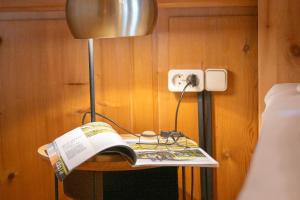 a book on a table with a lamp and a bed at Ferienwohnung Ritter in Schwarzenberg +21 photos