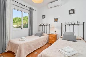 a bedroom with two beds and a window at Villa La Macera in Frigiliana +27 photos
