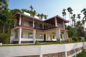 a house on a hill with palm trees at The Calm County Homestay in Mānantoddy +61 photos