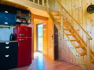 a red refrigerator in a kitchen with a staircase at Kiełpińska Stodoła in Rynek