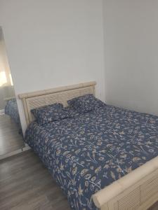 a bedroom with a bed with a blue comforter at Nice modern house, bright and quiet assured in Nantes