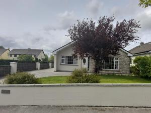 a house in the suburbs with a white fence at Home in Ballina, Ireland in Ballina