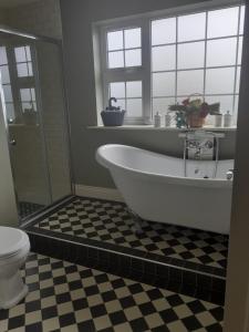a bath tub in a bathroom with a window at Home in Ballina, Ireland in Ballina