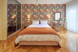 a bedroom with a large bed with a floral wallpaper at Rastoni Athens Suites near Acropolis in Athens