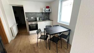 Una cocina con una mesa y sillas en una habitación. en Zeitwohnen in Hückeswagen -Neu-, en Hückeswagen