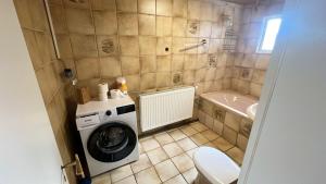 Un baño con lavadora y un inodoro. en Zeitwohnen in Hückeswagen -Neu-, en Hückeswagen 4 fotos más