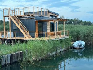 a house on a dock on the water with a boat at Era Cottage in Ulcinj