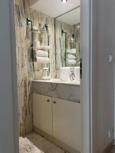 a bathroom with a sink and a mirror at Heart of Monte Carlo - 1 Min from the F1 Track in Monte Carlo