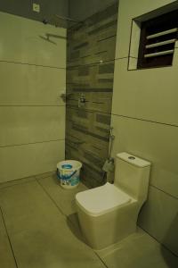 a bathroom with a white toilet in a room at The Calm County Homestay in Mānantoddy