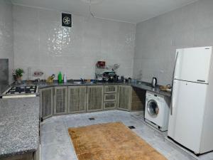 a kitchen with a white refrigerator and a washing machine at شقق ابو يزن عجلون بالقرب من محمية عجلون in Ajloun