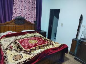 a bedroom with a bed with a red and yellow blanket at شقق ابو يزن عجلون بالقرب من محمية عجلون in Ajloun