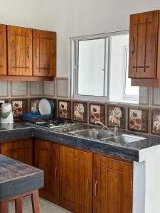 Una cocina con gabinetes de madera y un fregadero. en Check Inn Motel, en Nikawatawana