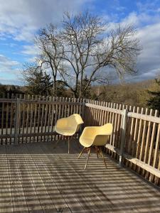 two chairs sitting on a deck next to a fence at Penthouse in Buttelstedt