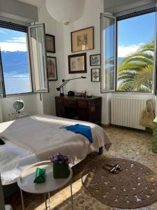 a bedroom with a bed and two large windows at Villa Pace - Garden with Private Lake Access in Gargnano