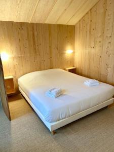 una camera da letto con un letto in una parete di legno di Le Cabanon du bord de mer a Cayeux-sur-Mer
