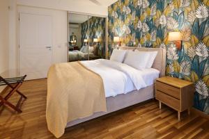 a bedroom with a large bed with a floral wallpaper at Rastoni Athens Suites near Acropolis in Athens