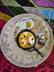 a plate with an egg in a frying pan on a table at Maison d'hotes Dar Aisha 
