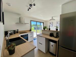 a kitchen with a sink and a refrigerator at La Colinette Chambretaud - 5min du PuyDuFou in Chambretaud