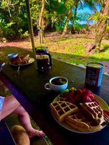 a table with a plate of food and waffles and drinks at Shared Beach House in Drake +34 photos