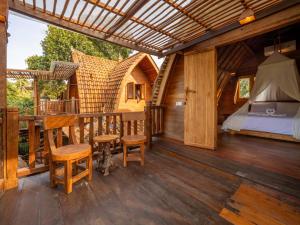 a porch of a house with a bed and a bedroom at Aruna Jayanti Villa in Tejakula
