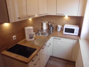 une petite cuisine avec un évier et un micro-ondes dans l'établissement Wellness-Appartement, à Westerland