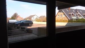 - une vue depuis la fenêtre d'une voiture garée sur un parking dans l'établissement Wellness-Appartement, à Westerland