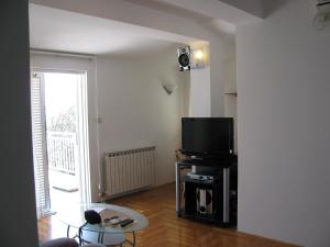 a living room with a tv and a table at kutlesa 2 in Opatija