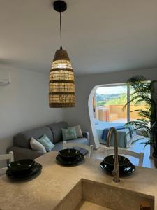 eine Küche mit Spüle und ein Wohnzimmer in der Unterkunft Appartamento Spiaggia Marinella con vista mare e piscina, Costa Smeralda in Marinella