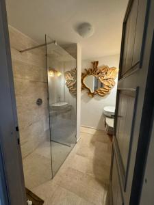 ein Bad mit einer Dusche, einem WC und einem Spiegel in der Unterkunft Appartamento Spiaggia Marinella con vista mare e piscina, Costa Smeralda in Marinella + 10 Fotos