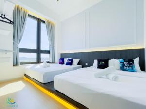 due letti bianchi in una stanza con una finestra di Sunway Grid by RR JBcity a Iskandar Puteri