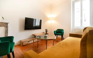 a living room with a couch and a table and a tv at Le Gare Nord T3 de Haut Standing Cosy et Relaxant in Nantes +4 photos