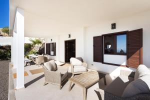 un salon avec des meubles blancs et une grande fenêtre dans l'établissement Finca Villa La Palmera, amazing sea views, à Arafo