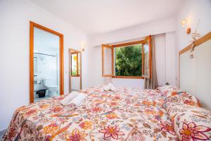 a bedroom with a bed and a bathroom with a window at Apartamento Felipe 2-4 in Cala d´Or