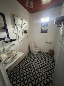 a bathroom with a toilet and a black and white floor at Daily Free Trekking Tour - Nguyen Shack in Phong Nha
