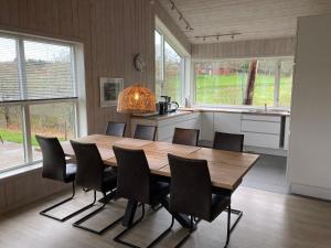 a dining room with a wooden table and chairs at Storeval feriehus Nærøysund in Kolvereid +31 photos