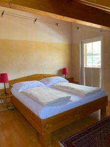 a bedroom with a large wooden bed with two lamps at Techendorf 101 in Weissensee