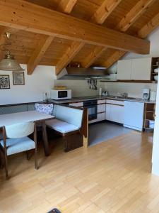 a kitchen with a table and chairs in a room at Techendorf 101 in Weissensee