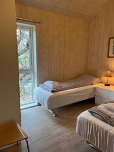 a bedroom with two beds and a window at Storeval feriehus Nærøysund in Kolvereid
