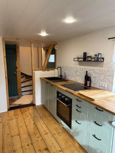 a kitchen with a sink and a stove top oven at Ferienhaus KellerwaldChalet in Jesberg mit großem Garten zur Alleinnutzung in Jesberg
