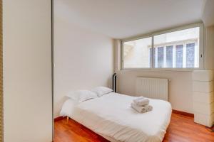 a bedroom with a white bed and a window at Spacious, quiet flat in the heart of Bordeaux in Bordeaux +19 photos