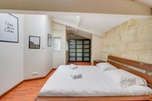 a bedroom with a large white bed and a brick wall at Spacious, quiet flat in the heart of Bordeaux in Bordeaux
