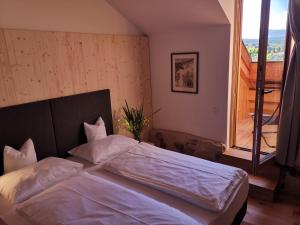 a bedroom with a large bed with a large window at Ansitz Grustdorf in Appiano sulla Strada del Vino