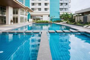 a swimming pool in front of a building at Sophie's Staycation 1 BR condo in Bacolod