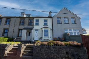 a large house with a stone wall in front of it at 3 bedroom - Sea View - Pet Friendly in Pistyll